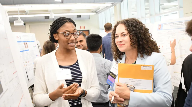 Two researchers discussing work during a poster session