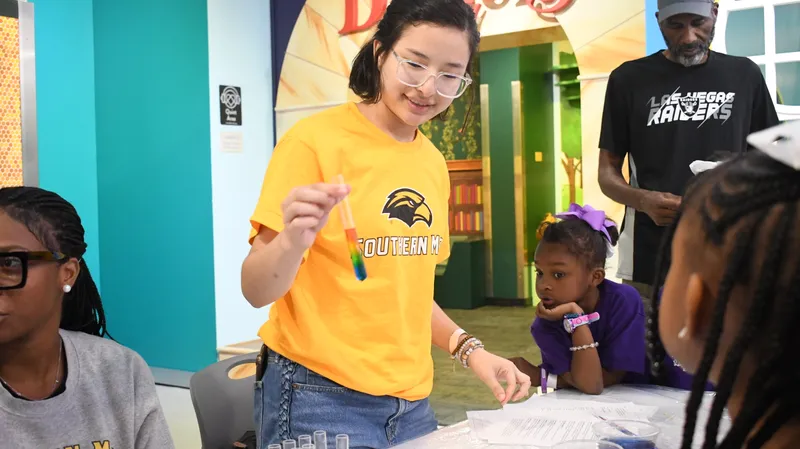A Southern Miss student leading a hands-on science activity with children