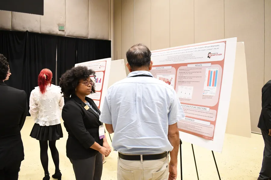 A researcher sharing findings with an attendee at a poster session